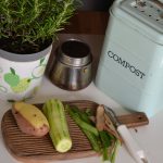 Small apartment kitchen with a countertop compost bin, representing eco-friendly living in 2025.