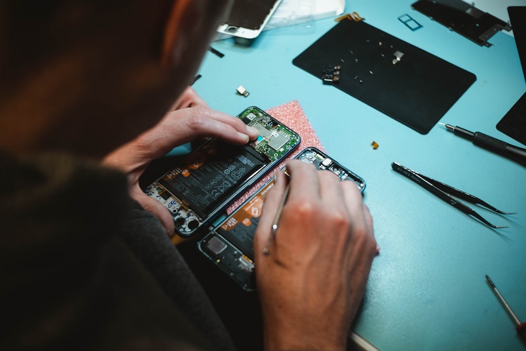 Repairability in electronics shown by person fixing smartphone battery.
