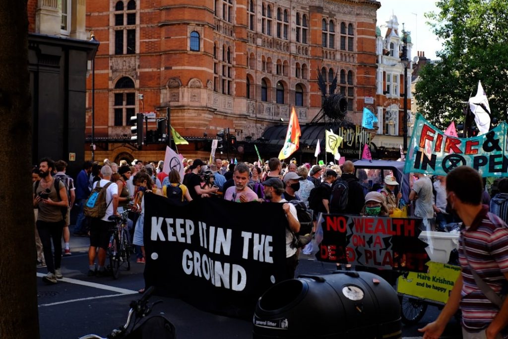 Climate activists holding a Keep It in the Ground protest sign in 2025 against fossil fuels and for sustainability